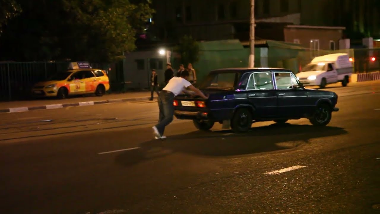 ロシア・モスクワで車を押して諦める人。
